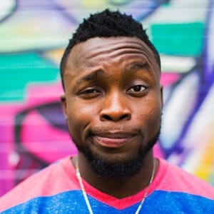 Close-up portrait of a male with a unique facial expression against a colorful background.